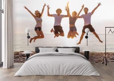 Group of friends together on the beach having fun. Happy young people jumping on the beach. Group of friends enjoying summer vacation on a beach. Wall mural