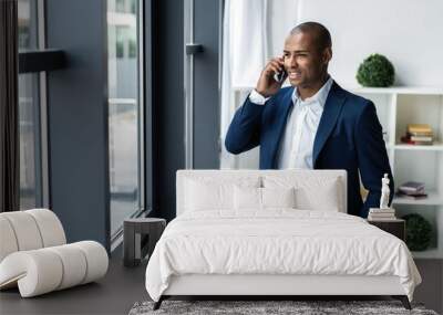 handsome african american businessman talking on mobile phone in modern office. Wall mural