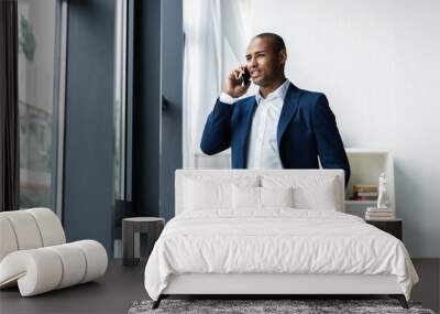 handsome african american businessman talking on mobile phone in modern office. Wall mural