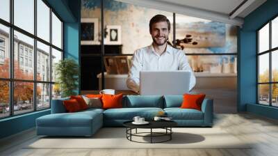 Handsome businessman working with laptop in office Wall mural