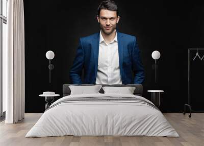 Handsome man wear blue suit isolated on black background Wall mural