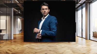 Handsome man wear blue suit isolated on black background Wall mural