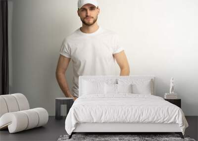 Handsome man wearing blank white cap and white t-shirt isolated on white background. Wall mural