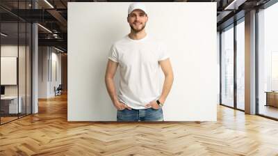 Handsome man wearing blank white cap and white t-shirt isolated on white background. Wall mural