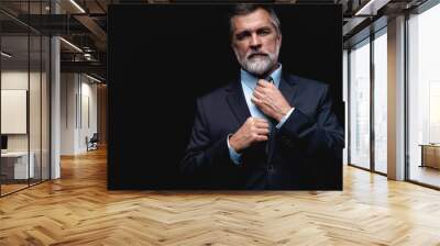 Handsome mature business man isolated on black background Wall mural