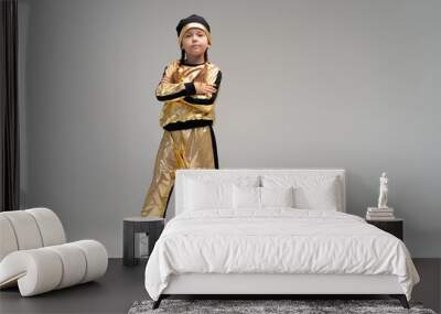 Happy little girl in gold suit dancing isolated on white background Wall mural