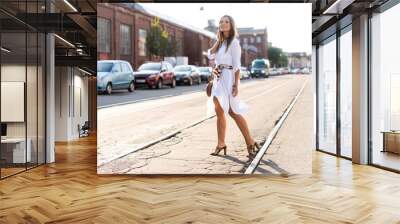 Happy young business woman walking on the street. Wall mural