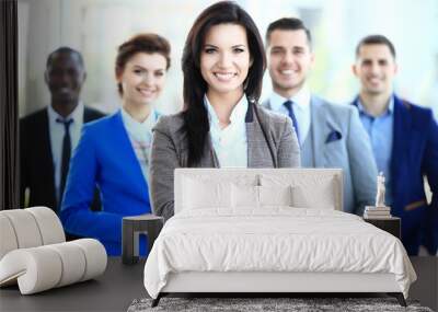 happy young female business leader standing in front of her team Wall mural