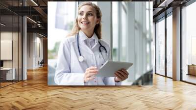 healthcare, technology and medicine concept - smiling female doctor with stethoscope taking notes at tablet pc computer. Wall mural