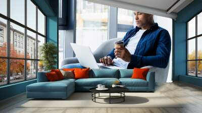 Image of african american businessman working on his laptop. Handsome young man at his desk Wall mural