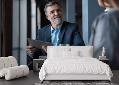 Image of mature businessman interviewing female. Wall mural