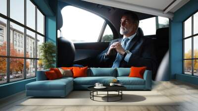 Mature handsome businessman is sitting in luxury car. Serious bearded man in suit. Wall mural