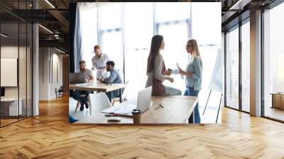 Office life. Group of young business people working and communicating together in creative office. Wall mural