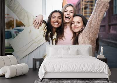 Outdoor shot of three young women having fun on city street Wall mural