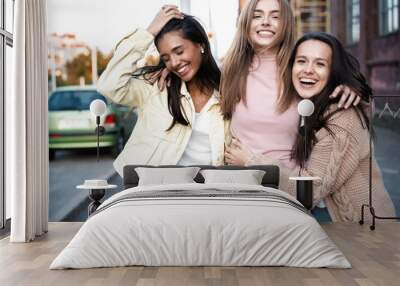 Outdoor shot of three young women having fun on city street Wall mural