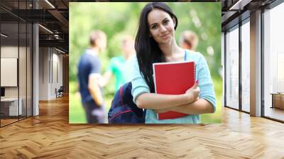 Outdoors portrait of a beautiful tanned teen student girl. Wall mural