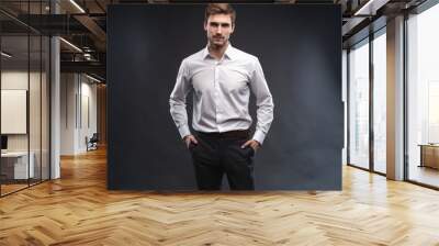 Portrait of a handsome young businessman dressed in suit isolated over gray background. Wall mural