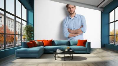 Portrait of a smart young man standing against white background. Wall mural