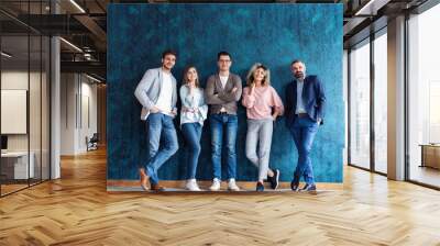 Portrait of creative business team standing together and laughing. Multiracial business people together at startup Wall mural