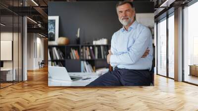 Portrait of happy successful businessman at work. Senior business man standing by office desk in office. Wall mural