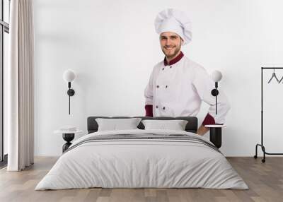 Portrait of positive handsome chef cook in beret and white outfit isolated on white background. Wall mural