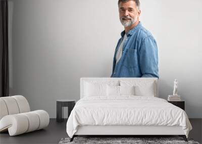 Portrait of smiling mature man standing on white background. Wall mural