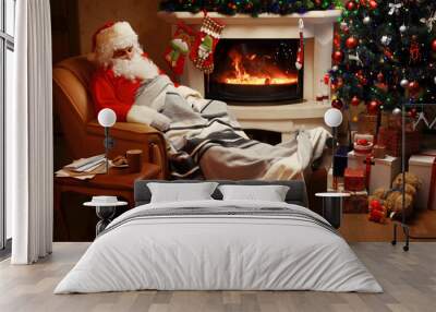 Santa Claus having a rest in a comfortable chair near the fireplace at home Wall mural