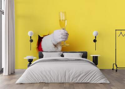 Santa Holding Champagne Flute isolated over light yellow. Hand and arm only Wall mural