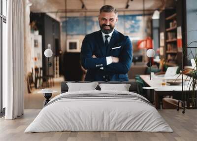 Stylish bearded man in a suit standing in modern office Wall mural