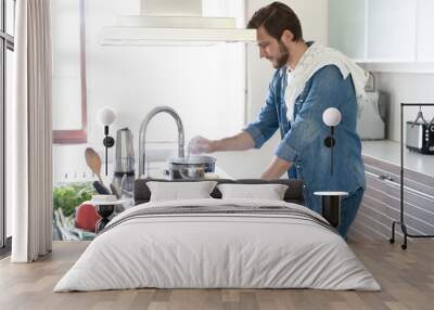 The steam from A man hand lifting a glass lid of the pot in the kitchen Wall mural