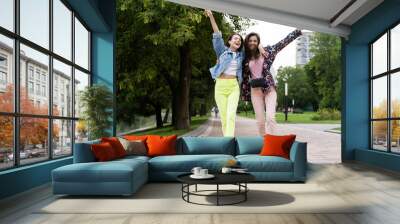 Two cheerful young girls walking in the Park Wall mural