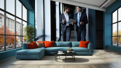 Two colleagues communicating in corridor, partners walking in the modern office Wall mural