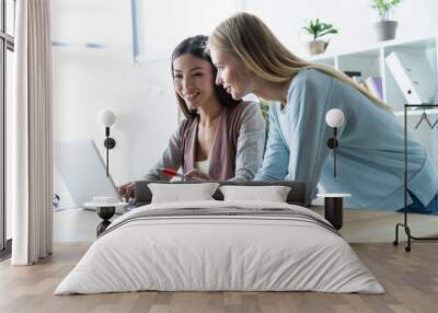 Two female colleagues in office working together. Wall mural