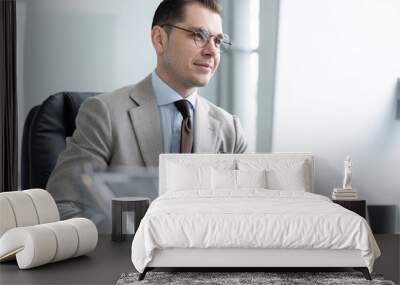 Young employee looking at computer monitor during working day in office Wall mural