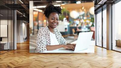 Smiling african american businesswoman with vitiligo skin condition working on a laptop in a modern office, black woman entrepreneur hd Wall mural