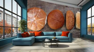 Freshly baked bread loaf bun roll round long mix verity on wooden over rustic wooden background Wall mural