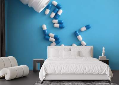 pills capsules with bottle isolated on blue background Wall mural