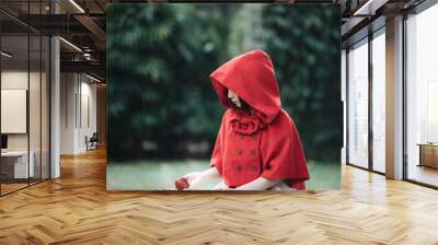 Portrait young woman with Little Red Riding Hood costume in green tree park Wall mural