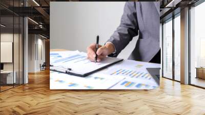 Asian businesswoman sit at their desks and calculate financial graphs showing results about their investments and plan successful business growth process Wall mural