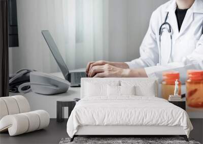 The female doctor sat and checked the patient's history and used a laptop to record patient information at the hospital. Medical concepts and interests Wall mural