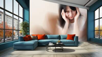 Young female suffering from dizziness, vertigo, headache while sitting on couch at home. Cause of dizzy inclued migraine, stress, stroke, BPPV, Meniere’s disease or brain tumor. Health care problem. Wall mural