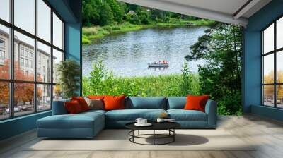 Four men boat and paddle on lake. Rowing, water sports and vacation in Sweden, sunshine and nature Wall mural