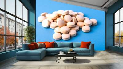 Orange pills vitamin C. pills on blue background. Wall mural