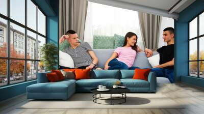 couple and friend, relationship and friendship challenge, three people, teenagers sitting on sofa, bored and  jealousy third person concept Wall mural