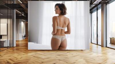 Back view of young fit healthy woman weared lingerie in bedroom Wall mural