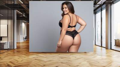 Plus size model in black lingerie, overweight female body, fat woman on gray background Wall mural