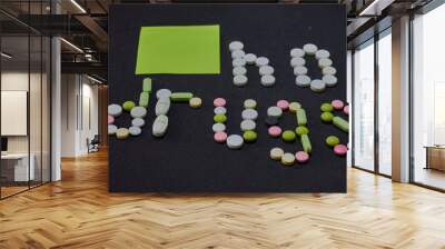 Medication white colorful round tablets arranged abstract on black color background. Aspirin, capsule pills, paper sticker sheet, text no drugs.  Wall mural