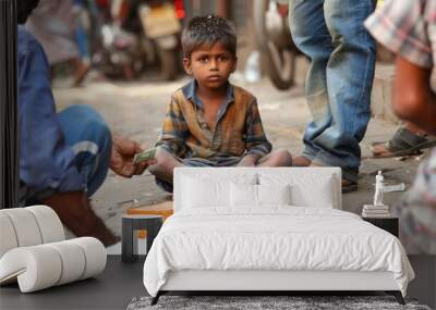 A poor Indian boy sat in the market begging. Wall mural