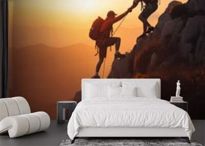 Climbers helping each other climb rocks at sunset on the mountain.Helps and team work concept Wall mural