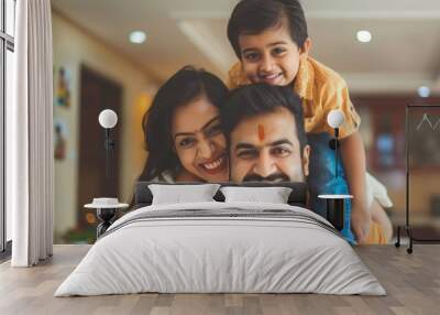 Happy Indian couple with son playing by fathers piggyback at home Wall mural